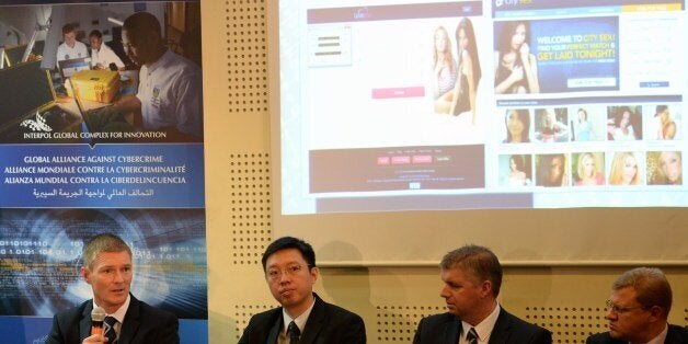 Detective Chief Inspector Gary Cunningham, of Scotland major investigation team (L) speaks as Chief Inspector Louis Kwan of Hong Kong's police commercial crime bureau (2nd L) and two unidentified men listen during a press conference at the police headquarters in Manila on May 2, 2014. Fifty-eight people have been arrested in the Philippines for their involvement in a giant, global Internet 'sextortion' network, local police and Interpol announced on May 2. AFP PHOTO/TED ALJIBE (Photo credit should read TED ALJIBE/AFP/Getty Images)