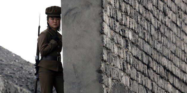 A North Korea woman soldier patrols the bank of the Yalu River which separates the North Korean town of Sinuiju from the Chinese border town of Dandong, northeast China's Liaoning province on April 26, 2014. North Korea is a 'pariah state' whose heavily militarised border with the South marks 'freedom's frontier', US President Barack Obama told American troops in Seoul as he wraps up a two day visit to South Korea, said Pyongyang's continued pursuit of nuclear weapons is 'a path that leads only to more isolation'. CHINA OUT AFP PHOTO (Photo credit should read STR/AFP/Getty Images)