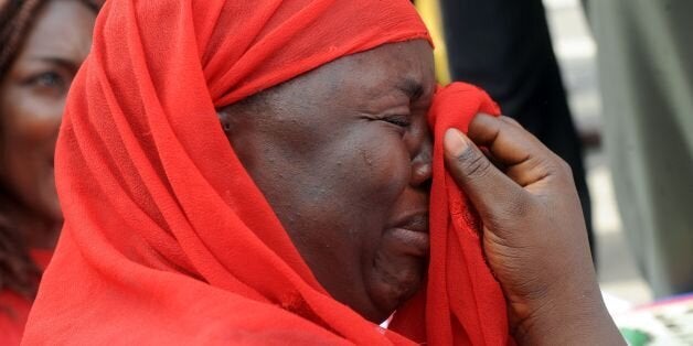 One of the mothers of the missing Chibok school girls wipes her tears as she cries during a rally by civil society groups pressing for the release of the girls in Abuja on May 6, 2014, ahead of World Economic Forum. Members of civil society groups marched through the streets of Abuja and to the Nigerian defence headquarters to meet with military chiefs, to press for the release of more than 200 Chibok school girls abducted three weeks ago. Suspected Boko Haram Islamists have kidnapped eight more girls from Nigeria's embattled northeast, residents said on May 6, after the extremist group's leader claimed responsibility for abducting more than 200 schoolgirls last month and said in a video he was holding them as 'slaves' and threatened to 'sell them in the market'. AFP PHOTO/PIUS UTOMI EKPEI / AFP / PIUS UTOMI EKPEI (Photo credit should read PIUS UTOMI EKPEI/AFP/Getty Images)