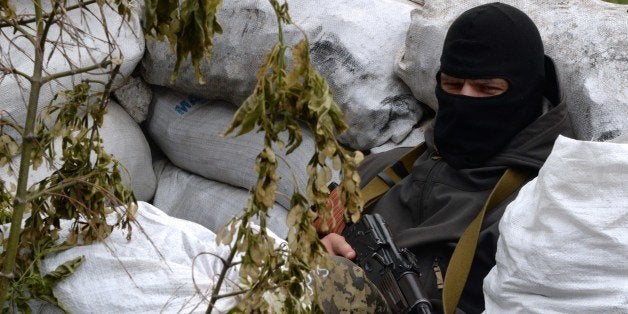 An armed pro-Russian fighter takes position at a checkpoint near the eastern Ukranian city of Slavyansk on May 12, 2014. Russia raised the stakes in the Ukraine crisis by saying it respected what rebels claimed was a resounding vote in favour of self-rule in the east of the country. But the Kremlin also called for dialogue between authorities in Kiev and rebel leaders, as European Union ministers prepared to meet in Brussels to consider toughening sanctions on Russia. AFP PHOTO / VASILY MAXIMOV (Photo credit should read VASILY MAXIMOV/AFP/Getty Images)