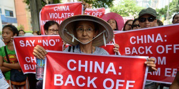 Vietnamese protesters hold placards during an anti-China rally with their Philippine counterparts (not pictured) in front of the Chinese consular office in the financial district of Manila on May 16, 2014. Several hundred Filipino and Vietnamese joined forces in a unique protest in the Philippine capital on May 16, demanding that China stop oil drilling in disputed South China Sea areas. AFP PHOTO/TED ALJIBE (Photo credit should read TED ALJIBE/AFP/Getty Images)