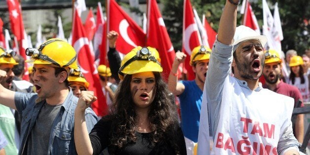 Protesters wearing hard hats raise their fists during a demonstration by the leftist Turkish Youth Union to protest the 301 deaths of the Soma coal mine accident and demand the Turkish prime minister's resignation, in Ankara on May 19, 2014. A total of five officials from mining company Soma Komur have now been charged with manslaughter, news agency Dogan reported, with more due before prosecutors on May 19, as the government promised 'a plan of action' to improve mining safety after the country's worst mining disaster claimed 301 lives. AFP PHOTO / ADEM ALTAN (Photo credit should read ADEM ALTAN/AFP/Getty Images)