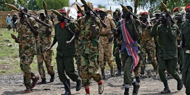 Members of the South Sudan Democratic Movement/Army (SSDM/A) faction march in Gumuruk on May 13, 2014. The faction's leader, David Yau Yau signed a final peace deal with the South Sudanese government on May 9, 2014 in the Ethiopian capital, Addis Ababa. Mediators who brokered South Sudan's fragile ceasefire called on May 13 for the warring sides to abide by the deal, with bloodshed showing no sign of stopping despite promises made on paper. Fighting broke out soon after dawn on May 11, a day after the ceasefire was signed by President Salva Kiir and rebel chief Riek Machar, the second time in the five-month conflict that a truce has failed to stick. AFP PHOTO/SAMIR BOLAFP PHOTO/ SAMIR BOL (Photo credit should read SAMIR BOL/AFP/Getty Images)