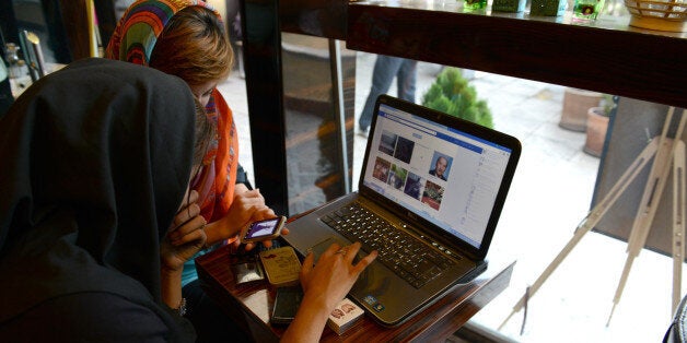 TEHRAN, IRAN - OCTOBER 13: Two girls sit in a north Tehran coffee shop using Facebook and looking on the mobile phone at online fashion clothing in Tehran, Iran on October 13, 2013 in Tehran, Iran. Socila media networks such as Facebbok, Twitter, Youtube are filtered in Iran and users can only access these sites using a virtual private network otherwise known as VPN. (Photo by Kaveh Kazemi/Getty Images)