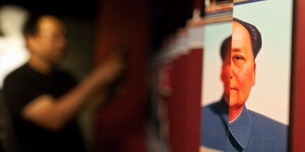 A visitor takes a photo of an exhibit showing the portrait of the late Chinese leader Mao Zedong (R) during the opening of the world's first museum dedicated to the Tiananmen Square crackdown, in Hong Kong on April 26, 2014, almost 25 years after the bloody incident took place. The permanent exhibition commemorates those killed in the authorities' brutal crushing of pro-democracy protesters in Beijing on June 3-4, 1989, in the city, one of the only places in China where the event can be commemorated. AFP PHOTO / ANTHONY WALLACE (Photo credit should read ANTHONY WALLACE/AFP/Getty Images)