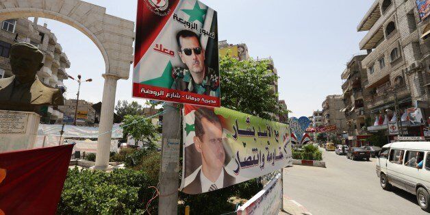 Election posters of President Bashar al-Assad hang in a roundabout in Jaramana near Damascus on May 28, 2014. Syrian President Assad is preparing for an inevitable re-election next week as the civil war shifts in the army's favour, with rebels losing ground and world powers paralysed by divisions. AFP PHOTP/ LOUAI BESHARA (Photo credit should read LOUAI BESHARA/AFP/Getty Images)