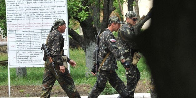 Pro-Russian militants walk on the grounds of the Ukrainian National guard unit in the eastern Ukrainian city of Lugansk on Ma