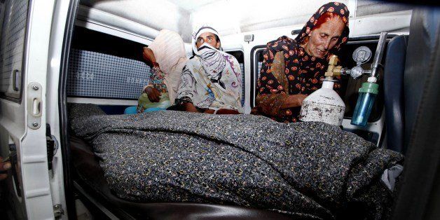 In this photograph taken on May 27, 2014 Pakistani relatives transport the body of a pregnant woman who was beaten to death with bricks by members of her own family for marrying a man of her own choice in Lahore. The husband of a pregnant Pakistani woman who was beaten to death outside Lahore's High Court for marrying against her family's wishes vowed to fight for justice. Farzana Parveen, 25, was attacked outside Lahore's grand high court building by more than two dozen brick-wielding attackers including her brother and father, who has been arrested, police said. AFP PHOTO (Photo credit should read STR/AFP/Getty Images)