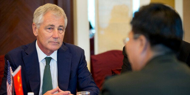 SINGAPORE - MAY 31: US Defense Secretary Chuck Hagel, left, listens to Lt. Gen. Wang Guanzhong, right, China's deputy chief of general staff, speak at the start of their meeting on May 31, 2014 in Singapore. Hagel warned an international security conference Saturday that the U.S. 'will not look the other way' when nations such as China try to restrict navigation or ignore international rules and standards. (Photo by Pablo Martinez Monsivais - Pool/Getty Images)