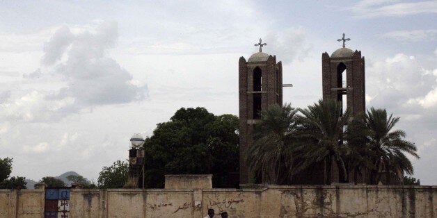 Two Sudanese youths ride their motorcycle past a church in Kadugli, the capital of Sudan's war-torn South Kordofan state, on June 19, 2013. Insurgents from the Sudan People's Liberation Army-North (SPLA-N) , fighting since 2011 in South Kordofan, have since last year periodically shelled Kadugli, currently co-hosting the Council for East and Central Africa Football Association (CECAFA) Kagame Club Cup with Darfur. AFP PHOTO/EBRHAIM HAMID (Photo credit should read EBRAHIM HAMID/AFP/Getty Images)