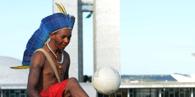 A Brazilian native plays football during a protest in front of the National Congress as part of Indigenous Mobilization Week,