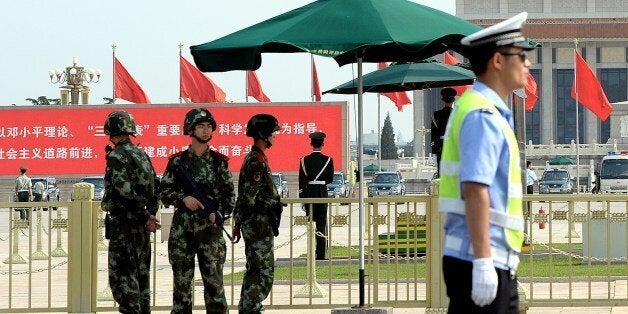 Armed Chinese police stand guard on Tiananmen Square in Beijing on June 3, 2014. A stepped-up police presence is visible on Beijing's streets, while dozens have been detained in the run-up to the 25th anniversary of the 1989 crackdown, as China moves to block any public commemoration. AFP PHOTO/GOH CHAI HIN (Photo credit should read GOH CHAI HIN/AFP/Getty Images)