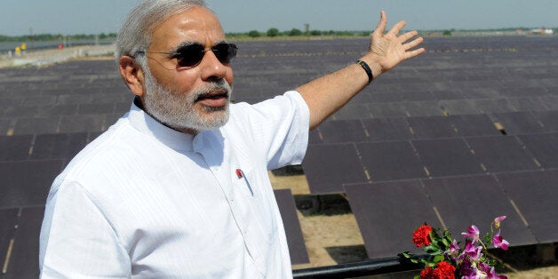 Chief Minister of the western Indian state of Gujarat Narendra Modi gestures as he poses at the inauguration of a solar farm