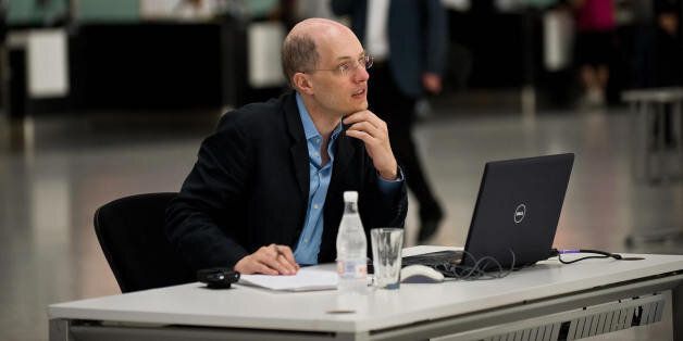 Author Alain de Botton writes at his desk in the check-in area during his week as writer-in-residence at Heathrow Airport, west London, on August 20, 2009. London's Heathrow airport has appointed a writer-in-residence to muse on the world of flight delays, passport controls and duty-free shops, officials said Wednesday. Alain de Botton, a popular philosopher known for works like 'How Proust Can Change Your Life', set up his laptop this week at the airport's new Terminal 5, where his writing appears on a screen behind him as he types. AFP PHOTO/Leon Neal (Photo credit should read Leon Neal/AFP/Getty Images)