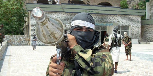 A Pakistani pro-Taliban militant carries rocket propelled granade launcher (RPG) as he stands inside the shrine in Lakaro vil