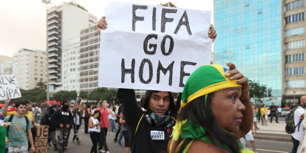 RIO DE JANEIRO, BRAZIL - JUNE 12: A protestor holds a 'FIFA Go Home' sign during an anti-World Cup demonstration in the Copa