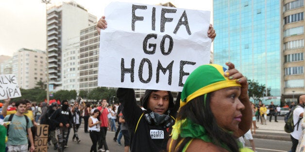 RIO DE JANEIRO, BRAZIL - JUNE 12: A protestor holds a 'FIFA Go Home' sign during an anti-World Cup demonstration in the Copacabana section on June 12, 2014 in Rio de Janeiro, Brazil. This is the first day of World Cup play. (Photo by Joe Raedle/Getty Images)