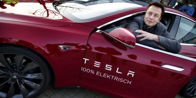 Elon Musk, co-founder and CEO of American electric vehicle manufacturer Tesla Motors, poses with a Tesla during a visit to Amsterdam on January 31, 2014. The European Tesla Service is based in Tilburg and the European headquarters is in Amsterdam. AFP PHOTO / ANP/ JERRY LAMPEN --NETHERLANDS OUT-- (Photo credit should read JERRY LAMPEN/AFP/Getty Images)