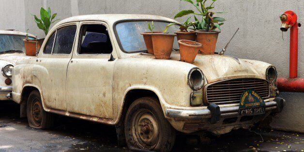An old defunct Ambassador 'State Car' hosts plant bearing pots at the basement of a government building in Bangalore on May 30, 2014. The maker of India's Ambassador car has suspended production, citing debt and lack of demand for the iconic vehicle which came to define the country's political class, a company official said May 24, 2014. Hindustan Motors, India's oldest car maker, has shut down its factory at Uttarpara in West Bengal state, where it has been making the Ambassador -- based on Britain's long-defunct Morris Oxford -- since 1957. AFP PHOTO/Manjunath KIRAN (Photo credit should read MANJUNATH KIRAN/AFP/Getty Images)