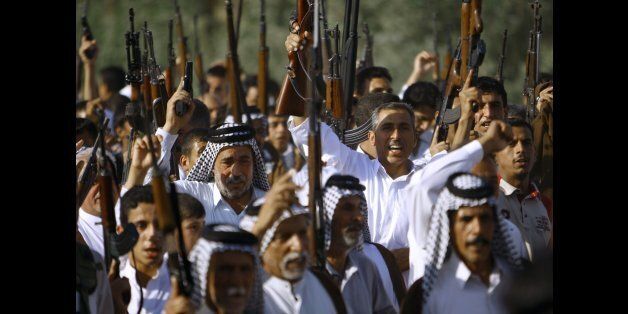 Iraqi Shiite tribesmen brandish their weapons as they gather to show their readiness to join Iraqi security forces in the fight against Jihadist militants who have taken over several northern Iraqi cities, on June 16 2014, in the southern Shiite Muslim shrine city of Najaf. Faced with a militant offensive sweeping south toward Baghdad, Prime Minister Nuri al-Maliki announced the Iraqi government would arm and equip civilians who volunteer to fight, and thousands have signed up. AFP PHOTO/HAIDAR HAMDANI (Photo credit should read HAIDAR HAMDANI/AFP/Getty Images)