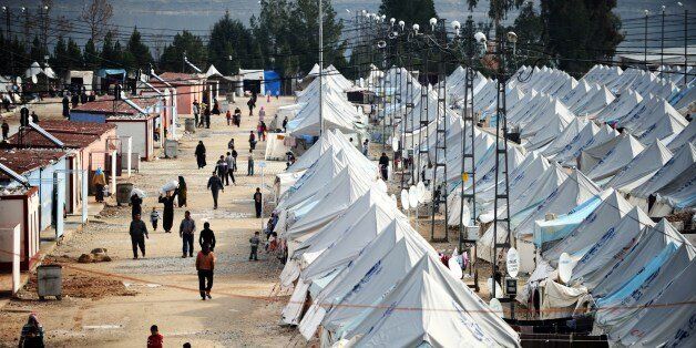 Syrian refugees walk among tents at Karkamis' refugee camp on January 16, 2014 near the town of Gaziantep, south of Turkey. Two weeks of battles between Syrian rebels and jihadists have killed at least 1,069 people, mostly fighters, the Syrian Observatory for Human Rights said Thursday. Among the dead, not all of whom were identified, were 608 Islamist and moderate rebels, 312 jihadists from the Islamic State of Iraq and the Levant (ISIL) and 130 civilians, the Britain-based group said. AFP PHOTO / OZAN KOSE (Photo credit should read OZAN KOSE/AFP/Getty Images)