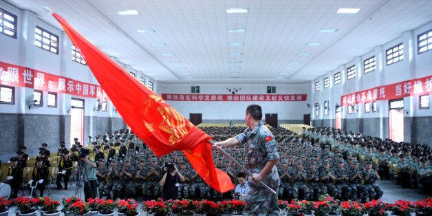 This photo taken on September 15, 2011 shows a Chinese People's Liberation Army (PLA) soldier waving a flag during a ceremony at their base in Luzhou, in southwest China's Sichuan province. In its rush for modernization, the Chinese People's Liberation Army (PLA), the largest army in the world, began an operation to seduce Chinese students, in an approach that offers an outlet for young graduates who are facing growing unemployment. CHINA OUT AFP PHOTO (Photo credit should read STR/AFP/Getty Images)