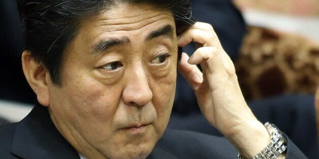 Japanese Prime Minister Shinzo Abe listens to a question during the Upper House's audit committee session at the National Diet in Tokyo on June 9, 2014. Abe told parliament that he would boost his efforts toward restarting commercial whaling, despite a top UN court's order that Tokyo must stop killing whales in the Antarctic. AFP PHOTO / JIJI PRESS JAPAN OUT (Photo credit should read JIJI PRESS/AFP/Getty Images)