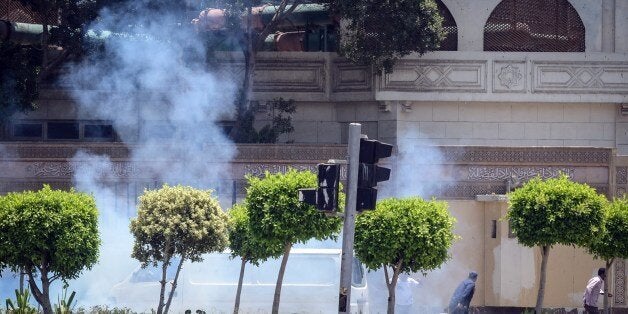 People run for cover moments after a bomb blast in the vicinity of the Ittihadiya palace in the Egyptian capital Cairo, on June 30, 2014. Two Egyptian police officers were killed defusing bombs near the presidential palace in Cairo almost a year to the day after a military takeover unleashed a wave of repression and militant attacks. AFP PHOTO/ MOHAMED EL-SHAHED (Photo credit should read MOHAMED EL-SHAHED/AFP/Getty Images)