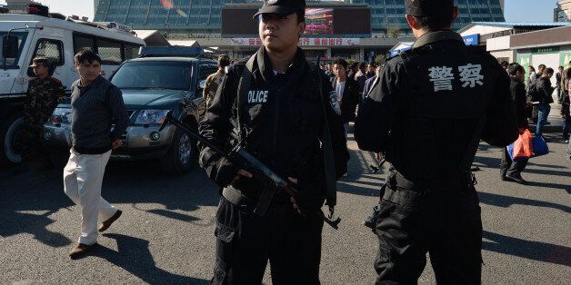 Chinese paramilitary police stand guard outside the scene of the terror attack at the main train station in Kunming, Yunnan Province, on March 3, 2014. Knife-wielding assailants left at least 29 people dead and more than 130 wounded in an unprecedented attack at a Chinese train station, with state media blaming separatists from Xinjiang. Victims described attackers dressed in black bursting into Kunming station in the southwestern province of Yunnan and slashing indiscriminately as people queued to buy tickets, prompting shock and outrage. AFP PHOTO/Mark RALSTON (Photo credit should read MARK RALSTON/AFP/Getty Images)