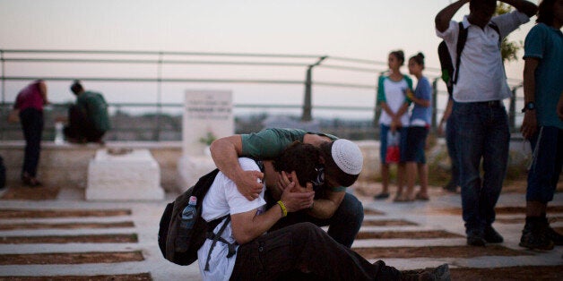 MODI'IN, ISRAEL - JULY 01: People mourn during the funeral ceremony held for the three Israeli teenagers found dead, on July 1, 2014 in Modiin, Israel. The bodies of Eyal Yifrah, 19, Gilad Shaar, 16, and Naftali Fraenkel, 16, were found on Monday, north of the Palestinian town Halhul, near Hebron. The teenagers were reported missing since June 12. (Photo by Ilia Yefimovich/Getty Images)