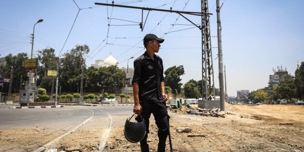 An Egyptian police officer looks on following a bomb blast in the vicinity of the Ittihadiya palace in the Egyptian capital C