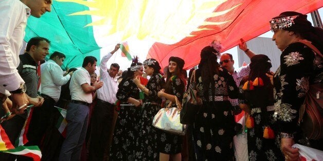 Iraqi Kurdish protesters deploy a giant flag of their autonomous Kurdistan region during a demonstration to claim for its independence on July 3, 2014 outside the Kurdistan parliament building in Arbil, in northern Iraq. The Kurdish leader, Massud Barzani asked its parliament to start organizing a referendum on independence. AFP PHOTO / SAFIN HAMED (Photo credit should read SAFIN HAMED/AFP/Getty Images)