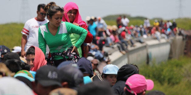 JUCHITAN, MEXICO - AUGUST 06: Central American immigrants ride north on top of a freight train on August 6, 2013 near Juchitan, Mexico. Thousands of Central American migrants ride the trains, known as 'la bestia', or the beast, during their long and perilous journey through Mexico to reach the U.S. border. Some of the immigrants are robbed and assaulted by gangs who control the train tops, while others fall asleep and tumble down, losing limbs or perishing under the wheels of the trains. Only a fraction of the immigrants who start the journey in Central America will traverse Mexico completely unscathed - and all this before illegally entering the United States and facing the considerable U.S. border security apparatus designed to track, detain and deport them. (Photo by John Moore/Getty Images)