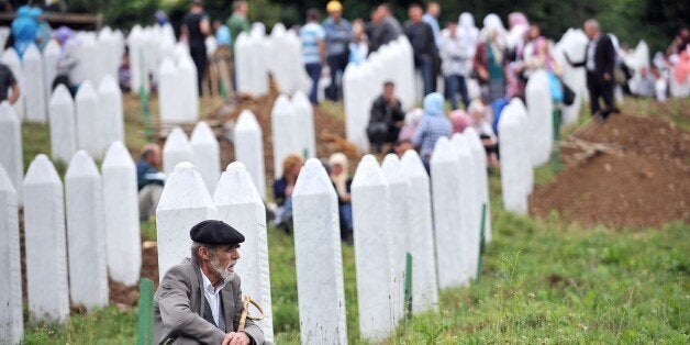 An elderly Bosnian Muslim man, survivor of the Srebrenica 1995 massacre, pays his respects at a relative's grave at the Srebr