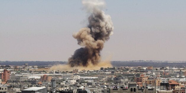 Smoke and dust rise following an Israeli air strike in Rafah, in the south of the Gaza Strip, on July 8, 2014. Israeli warplanes killed 13 Palestinians in Gaza with Israel weighing 'all options' in a new drive to stamp out Hamas rocket fire as the two sides slid toward another major conflict. AFP PHOTO/ SAID KHATIB (Photo credit should read SAID KHATIB/AFP/Getty Images)