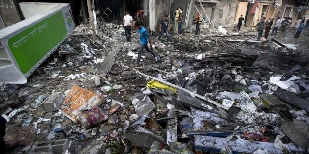 Palestinian inspect the destruction following an Israeli air strike in Gaza City on July 11, 2014. Israeli warplanes kept up deadly raids on Gaza but failed to stop Palestinian militants firing rockets across the border, as the United States offered to help negotiate a truce. AFP PHOTO/MOHAMMED ABED (Photo credit should read MOHAMMED ABED/AFP/Getty Images)