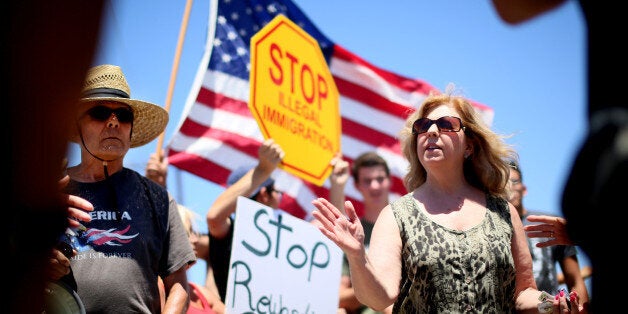 MURRIETA, CA - JULY 7: Immigrant rights activist Mary Estrada (R) speaks with anti-immigration activists during a protest outside of the U.S. Border Patrol Murrieta Station on July 7, 2014 in Murrieta, California. Immigration protesters have staged rallies in front of the station for about a week in response to a wave of undocumented immigrant children caught along the U.S.-Mexico border in Texas and transported to the Murrieta facility while awaiting deportation proceedings. (Photo by Sandy Huffaker/Getty Images)