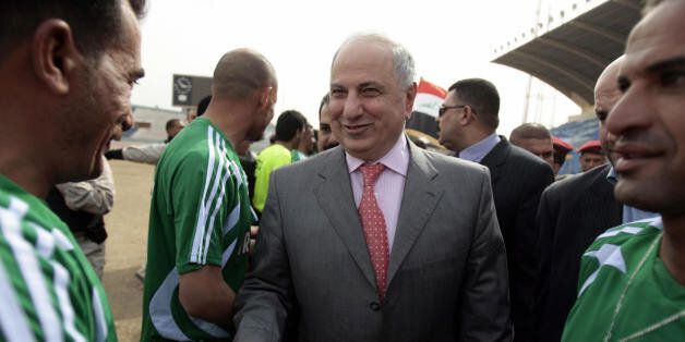 Former deputy prime minister Ahmed Chalabi (C) shakes hands with football players from Kadhimiyah, a Shiite neighbourhood, and Adhamiyah, a Sunni neighbourhood, during an exhibition match at the al-Shaab stadium in central Baghdad on February 17, 2008. The teams gathered for the match to celebrate the one year anniversary of the Baghdad security plan, which is largely credited with having significantly reduced violence in the capital. AFP PHOTO/AHMAD AL-RUBAYE (Photo credit should read AHMAD AL-RUBAYE/AFP/Getty Images)