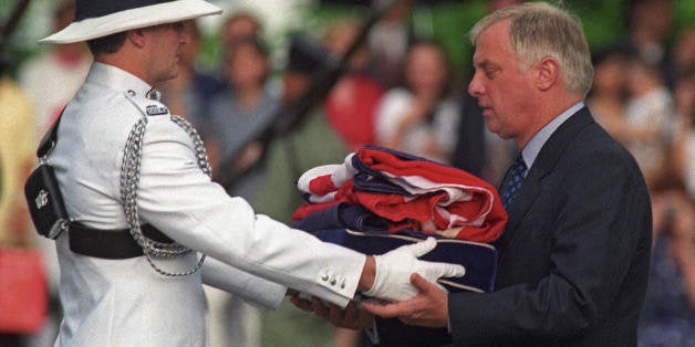 Hong Kong, HONG KONG: (FILES) Chris Patten (R), the 28th and last governor of colonial Hong Kong, receives the Union Jack flag after is was lowered for the last time at Government House - the governor's official residence - during a farewell ceremony in Hong Kong, 30 June 1997, just hours prior to the end of some 156 years of British colonial rule as the territory returns to Chinese control at midnight. China's southern coast prepares to mark the 10th anniversary of the handover 01 July, 2007. AFP PHOTO / FILES / EMMANUEL DUNAND (Photo credit should read EMMANUEL DUNAND/AFP/Getty Images)