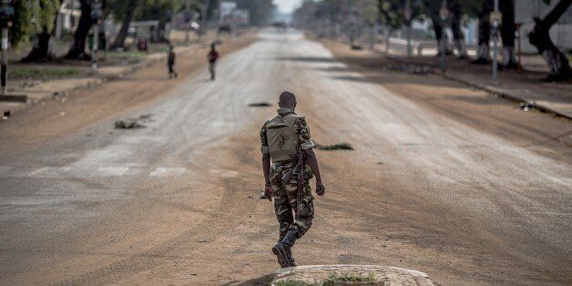 A soldier of the African-led International Support Mission to the Central African Republic (MISCA) crosses the main avenue at the Lakengua district of Bangui on May 29, 2014. At least 10 people were killed and several others wounded in clashes on May 28, 2014 in the capital of the strife-torn Central African Republic. The violence erupted during the afternoon close to the Notre-Dame de Fatima church in Bangui, according to a police officer and a military source. AFP PHOTO/MARCO LONGARI (Photo credit should read MARCO LONGARI/AFP/Getty Images)