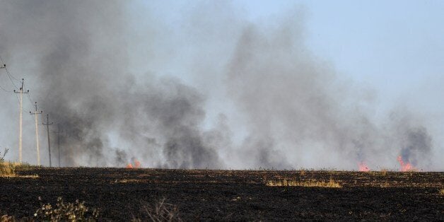 Smoke rises above a field after pro-Russia militants exchanged fire with the Ukranian army near the town of Marynivka, 100 km east of Donetsk, on July 16, 2014. EU leaders met on July 16 to decide on new sanctions against Russia and pro-Moscow separatists in east Ukraine as Kiev raises fears of an imminent invasion by thousands of Russian troops. AFP PHOTO / DOMINIQUE FAGET (Photo credit should read DOMINIQUE FAGET/AFP/Getty Images)