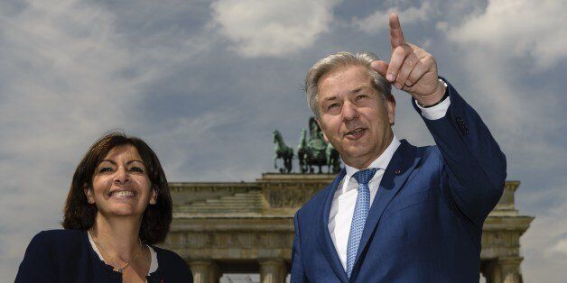 Anne Hidalgo (L), mayor of Paris, poses for a picture with her Berlin counterpart Klaus Wowereit (R), in front of the Brandenburg Gate in Berlin, Germany, during her visit on June 27, 2014. AFP PHOTO / CLEMENS BILAN (Photo credit should read CLEMENS BILAN/AFP/Getty Images)