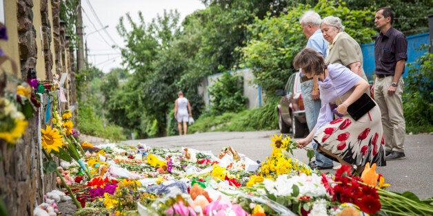 KIEV, UKRAINE - JULY 19: People leave flowers, candles and other tributes in front of the Malaysian Embassy in memory of the victims of Malaysia Airlines flight MH17 on July 19, 2014 in Kiev, Ukraine. Malaysia Airlines flight MH17 was travelling from Amsterdam to Kuala Lumpur when it crashed killing all 298 on board including 80 children. The aircraft was allegedly shot down by a missile and investigations continue over the perpetrators of the attack. (Photo by Rob Stothard/Getty Images)