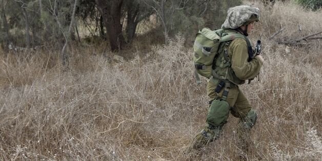 Israeli soldiers patrol an army deployment area near the Israeli-Gaza border,on July 19, 2014. Israeli strikes killed at leas