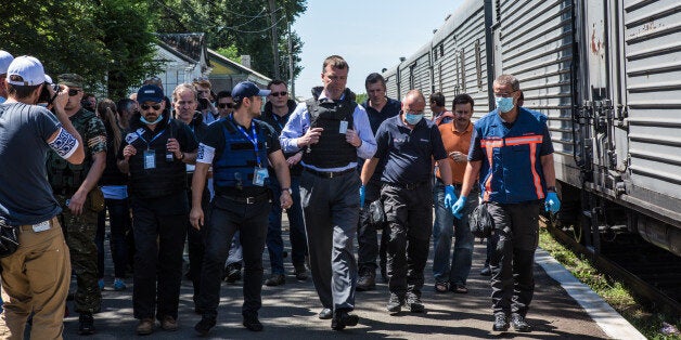 TOREZ, UKRAINE - JULY 21: Alexander Hug (C), Deputy Chief Monitor of the Organisation for Security and Cooperation in Europe (OSCE) Special Monitoring Mission to Ukraine, visits a train containing the bodies of victims of the Malaysia Airlines flight MH17 crash on July 21, 2014 in Torez, Ukraine. Together with Dutch inspectors, the storage conditions were declared acceptable, though it is still unclear where or when the train will be moved. Malaysia Airlines flight MH17 was travelling from Amsterdam to Kuala Lumpur when it crashed killing all 298 on board including 80 children. The aircraft was allegedly shot down by a missile and investigations continue over the perpetrators of the attack. (Photo by Brendan Hoffman/Getty Images)