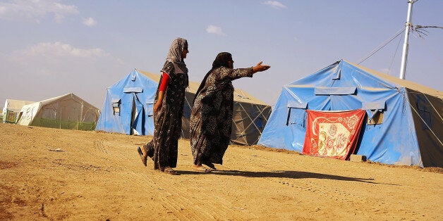 KHAZAIR, IRAQ - JUNE 28: Iraqi women walk inside of a displacement camp for those caught-up in the fighting in and around t