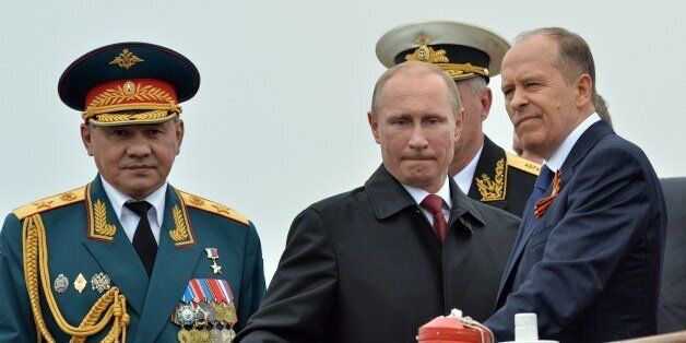 Russian President Vladimir Putin (C) reviews Russian naval ships in the Crimean port of Sevastopol on May 9, 2014, with head of the Federal Security Service (FSB) Alexander Bortnikov (R) and Defence Minister Sergei Shoigu (L) attending. Putin's visit to Crimea, which was annexed by Moscow in March, is a 'flagrant violation' of Ukraine's sovereignty, authorities in Kiev said today.AFP PHOTO/ YURI KADOBNOV (Photo credit should read YURI KADOBNOV/AFP/Getty Images)