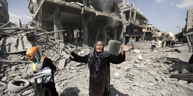 A Palestinian woman reacts at seeing destroyed homes in the northern district of Beit Hanun in the Gaza Strip during an humanitarian truce on July 26, 2014. Palestinians retrieved dozens of bodies from the rubble of Gaza homes during a brief truce in the fighting, raising to over 900 the overall death toll of Israel's onslaught on the territory since July 8, medics said. AFP PHOTO / MOHAMMED ABED (Photo credit should read MOHAMMED ABED/AFP/Getty Images)