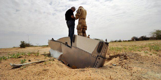 A French soldier talks with a representative of the Lebanese victims' relatives during a visit to the crash site of the Air Algerie Flight AH 5017 in Mali's Gossi region, west of Gao, on July 26, 2014. UN experts investigating the Air Algerie plane disaster in Mali have recovered the second black box from the doomed plane, a spokesman of UN peacekeepers in the country said on July 26. Officials who had already reached the remote, barren area described a scene of total devastation littered with twisted and burnt fragments of the plane that was carrying 118 on board, including entire families. No one survived the impact and France bore the brunt of the disaster with 54 nationals killed in the July 24 crash of the McDonnell Douglas 83, which had taken off from Ouagadougou in Burkina Faso and was bound for Algiers. AFP PHOTO/ SIA KAMBOU (Photo credit should read SIA KAMBOU/AFP/Getty Images)