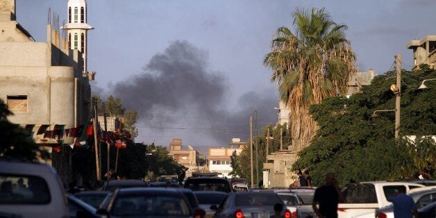 Smoke billows during clashes between security forces and armed groups near a Libyan army special forces barracks, on July 23,